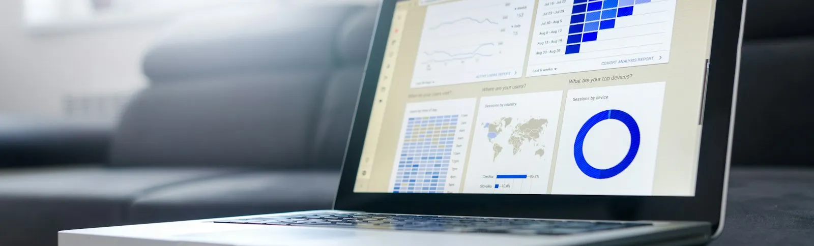 Notebook aberto com painel azul de resultados em sala escura